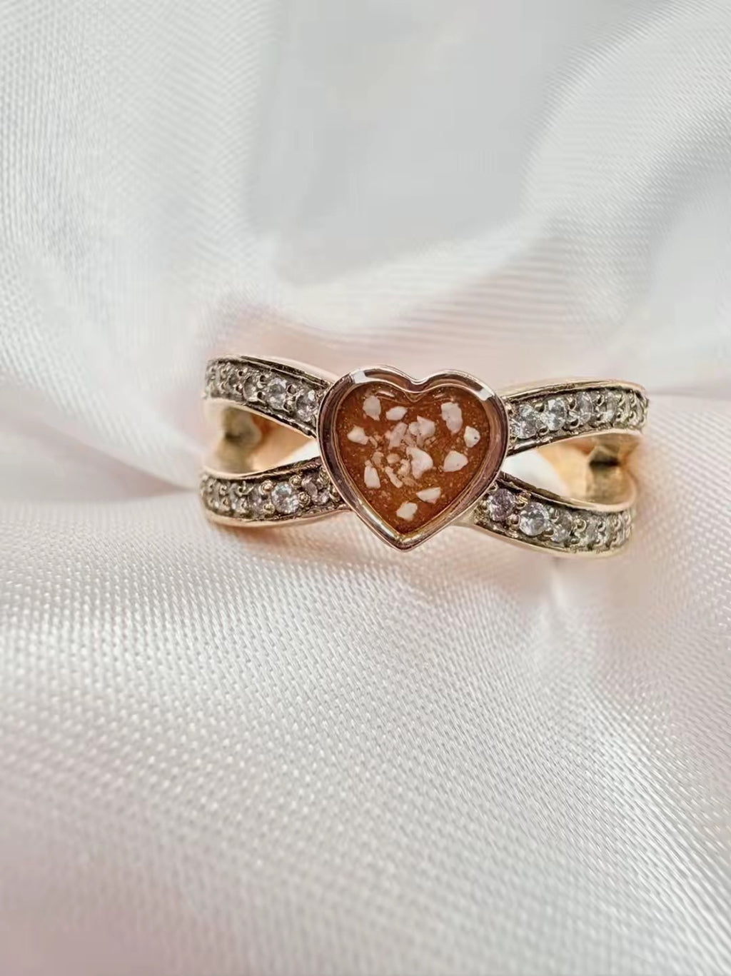 Solid gold heart ring, with ashes set in an orange stone.