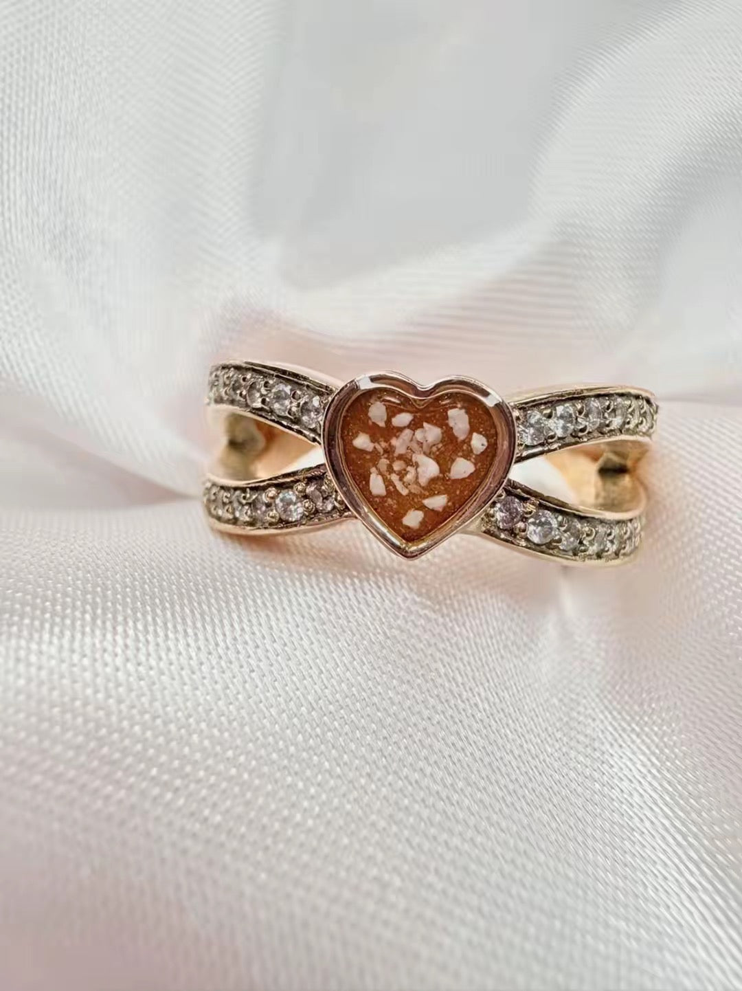Solid gold heart ring, with ashes set in an orange stone.